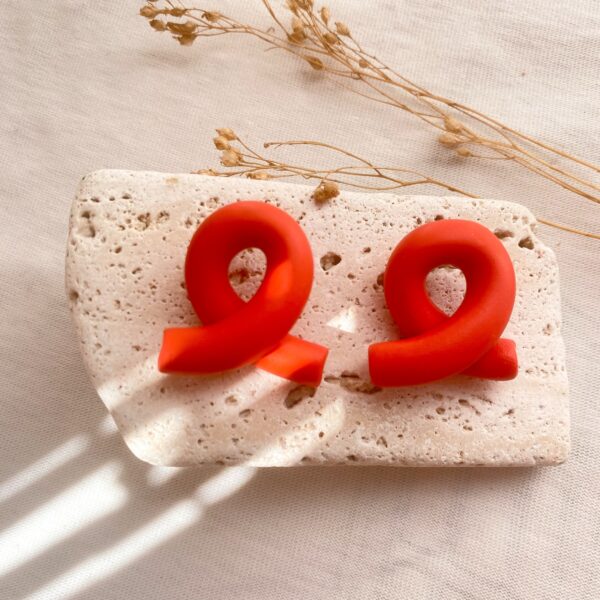 Arracada vermella de bot&oacute; en forma de nus.